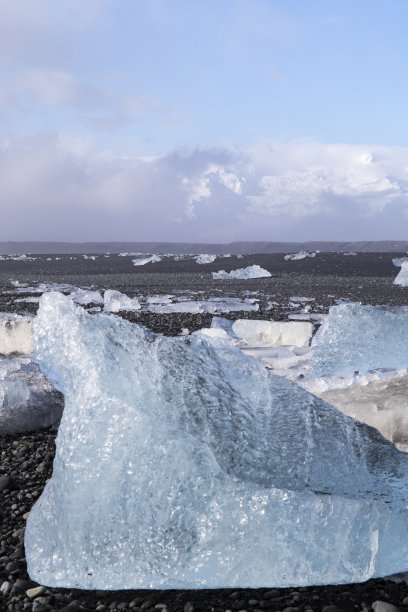 日出在著名的钻石海滩冰岛这个沙熔岩海滩图片下载