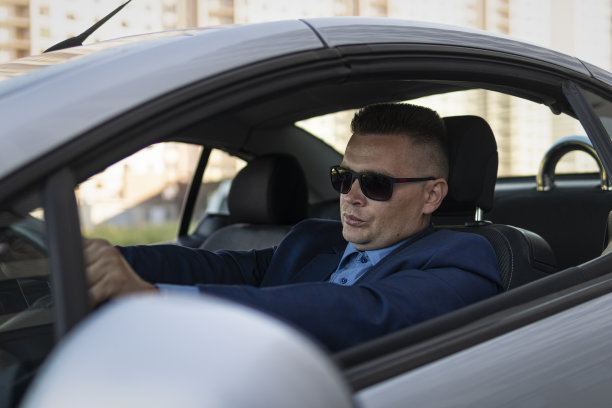 成功的商人开着一辆昂贵的敞篷车在城市里转悠。车上有个帅哥，商人图片下载