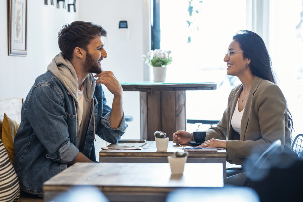 年轻可爱的夫妇在健康的咖啡店里一边喝咖啡，一边谈笑风生。图片下载