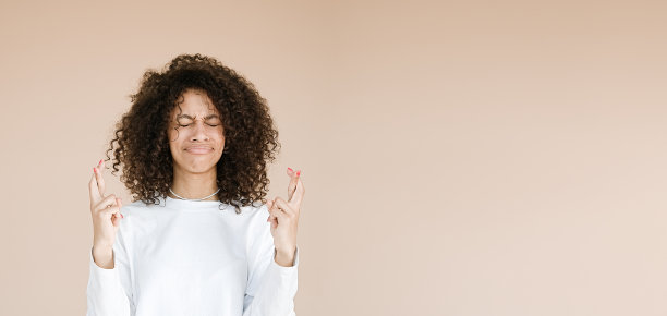 非裔美国妇女交叉手指的表情很惊讶图片下载