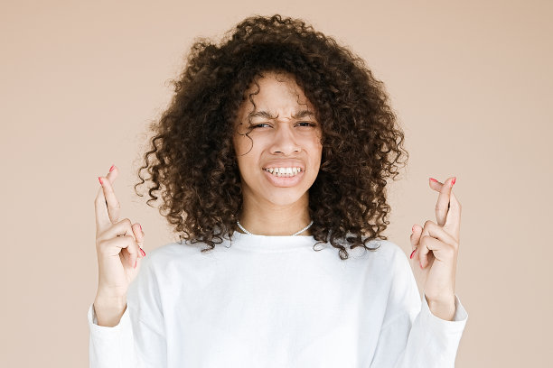 非裔美国妇女交叉手指的表情很惊讶图片下载