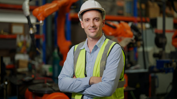 工程师肖像，肖像经理工程师在工厂使用机械臂工作。工程师编程机器人操作生产线制造。图片下载