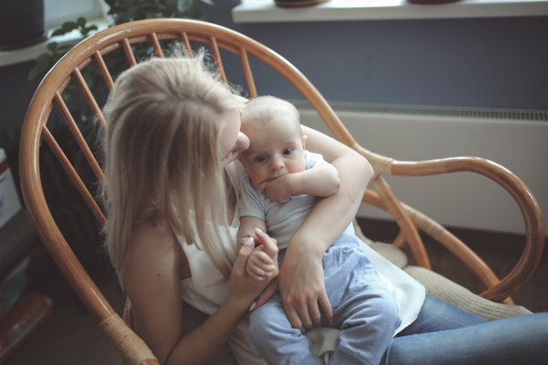 金发妈妈和她的宝贝儿子在扶手椅上聊天图片下载
