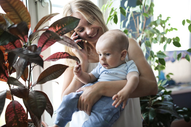 抱着孩子的妈妈在讲电话图片下载