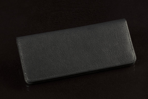 黑色背景的黑色皮夹。图片下载