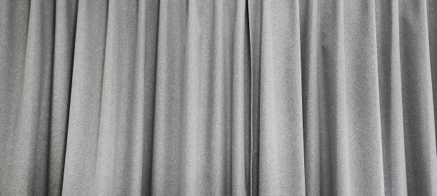 近看明亮的灰色窗帘在薄和厚垂直褶皱制成的黑色外粗麻布织物，窗帘的全景使用作为背景。有纹理的抽象背景和壁纸。图片下载