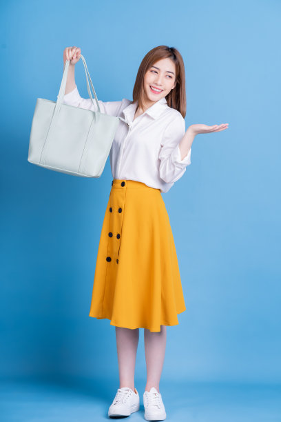 全长照片的年轻亚洲妇女在蓝色背景图片下载