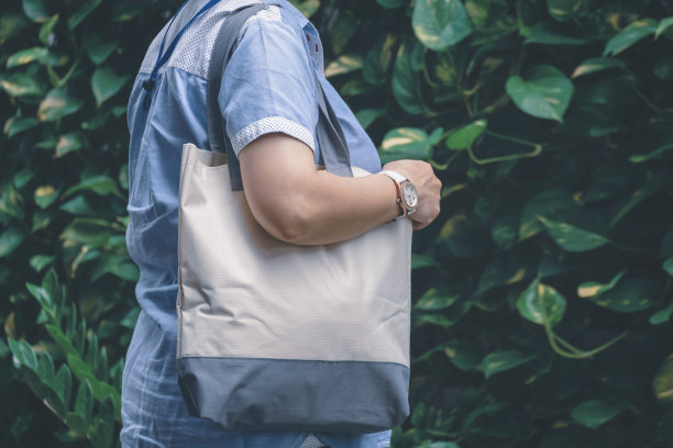 中部加尺码的妇女携带可重复使用的帆布环保手提袋模糊绿色植物墙背景图片下载