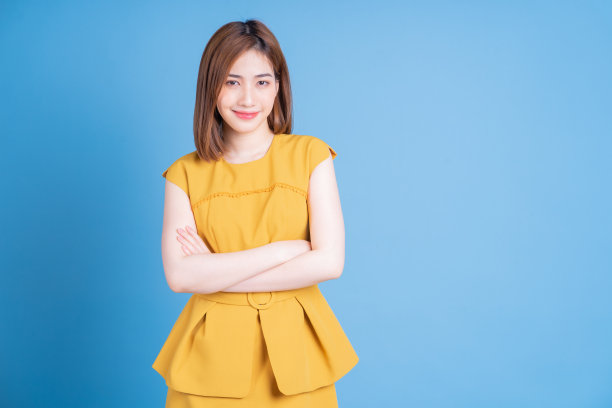 年轻的亚洲女性肖像摆蓝色背景图片下载