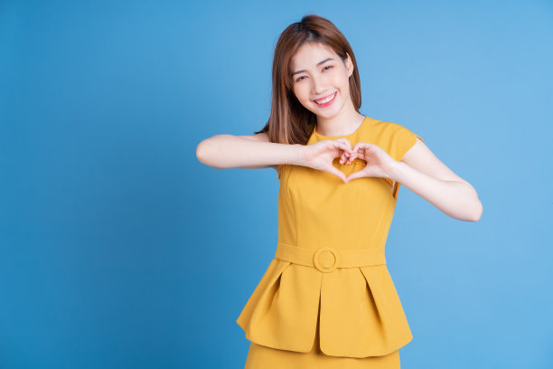 年轻的亚洲女性肖像摆蓝色背景图片下载