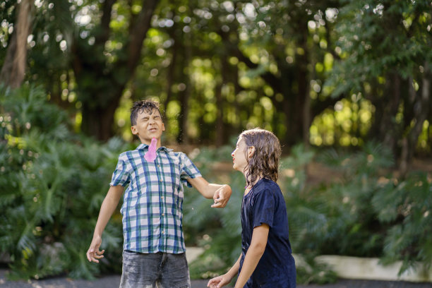 男孩们在他们的院子里玩水战图片下载