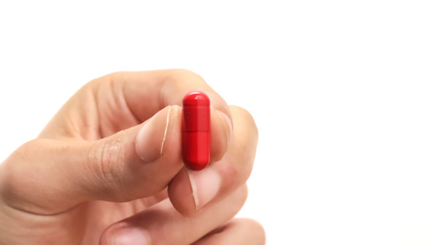 拿着白色背景和复印空间的红色药物胶囊图片下载