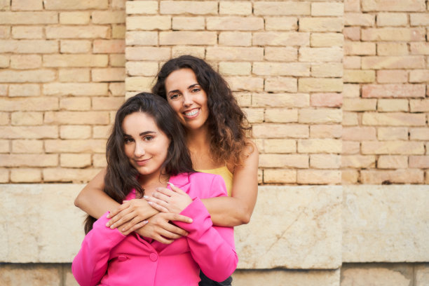 两个年轻女孩的肖像拥抱和看着相机-友谊的概念图片下载
