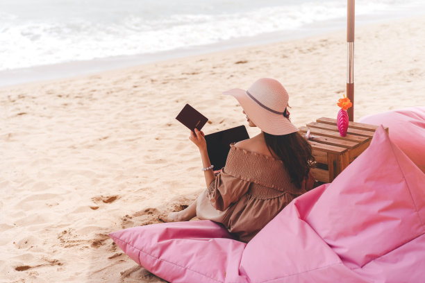在沙滩上持护照的年轻成年东南亚妇女的后视图图片下载