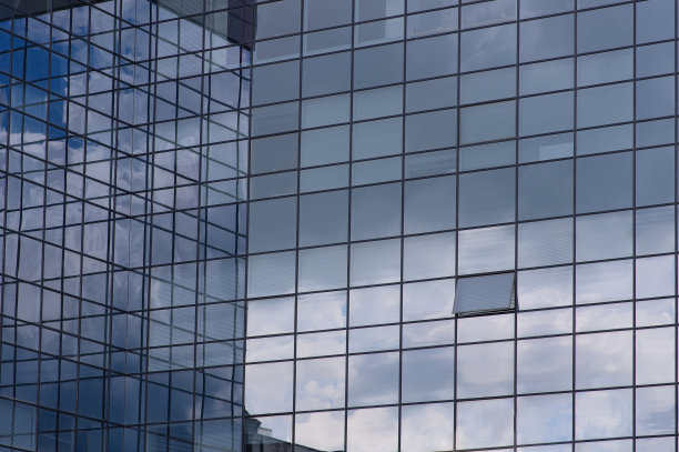 现代摩天大楼的窗户上反射着天空和云彩图片下载