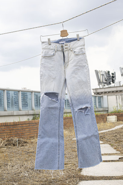 破洞牛仔裤挂在晾衣绳上图片下载