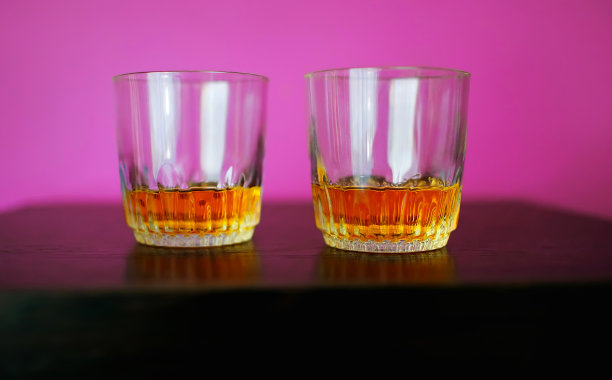 男人拿着一杯威士忌，穿着白衬衫站在办公室，垂直照片图片下载