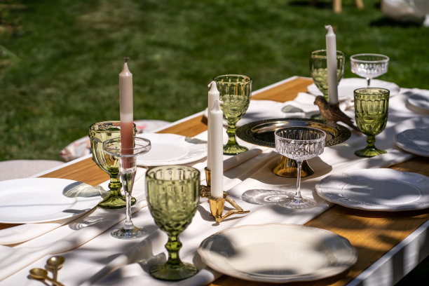 桌子已经摆好了，准备举行一个愉快的聚会。桌子摆好了。空盘子和不寻常的杯子。复古的托盘和烛台和花瓶与美丽的花朵。图片下载