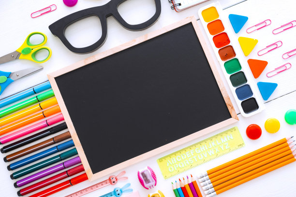 平铺文具粉笔板在一张白色背景的桌子上，打结。图片下载