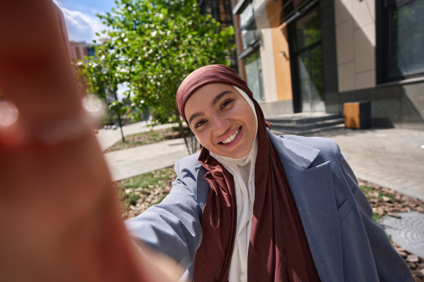 一名戴着头巾的阿拉伯妇女在电话上自拍图片下载
