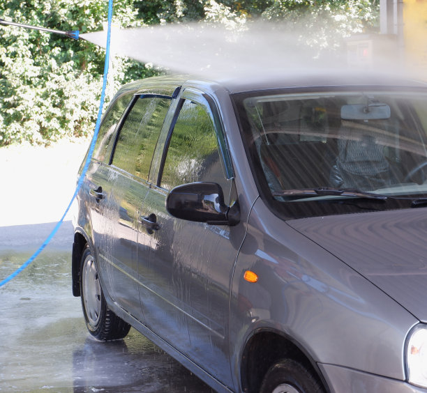 用高压清洗机洗车。水从水槽的喷嘴溅出来。图片下载