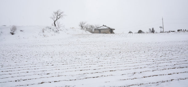 白雪皑皑的山上有一座房子。图片下载