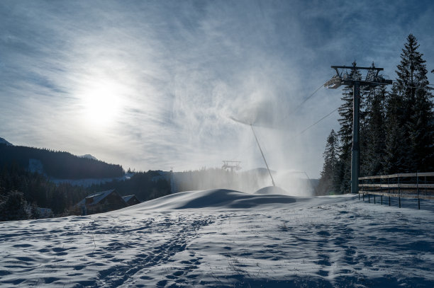 冬天山上的雪炮。喷着人造冰晶的雪枪。机器使雪。图片下载