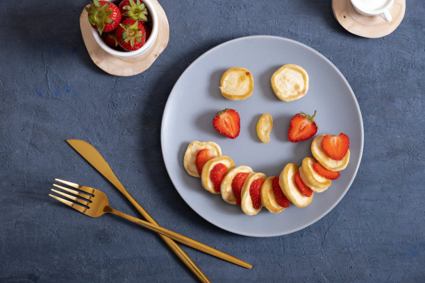 时髦食品煎饼麦片配草莓和酸奶。在黑色背景的盘子里堆迷你麦片煎饼。高质量的照片。俯视图图片下载