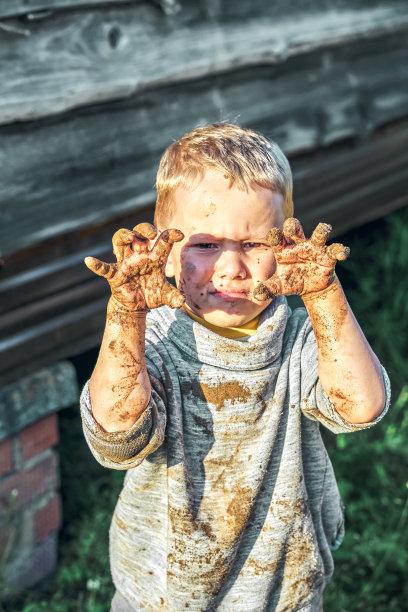 愤怒的男孩在沙盒里玩得脏兮兮的图片下载