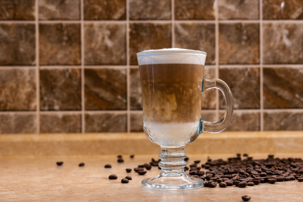 桌上有一杯卡布奇诺咖啡和咖啡豆。图片下载