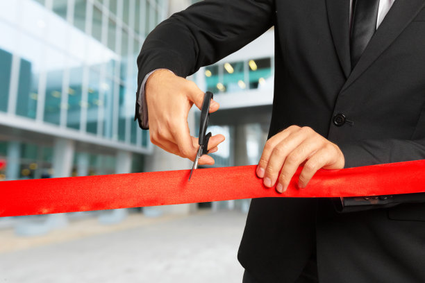 商人用剪刀剪红丝带图片下载