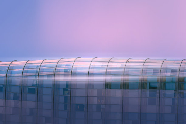 曲线玻璃建筑，深色钢窗系统，蓝色晴空背景，阳光明媚的现代办公大楼。图片下载