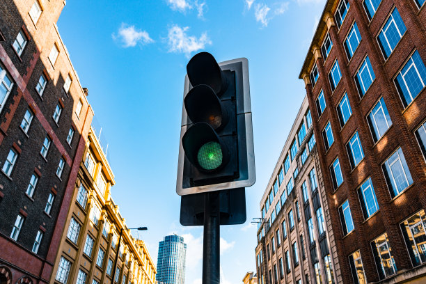 模糊的建筑背景下的绿色交通信号灯图片下载