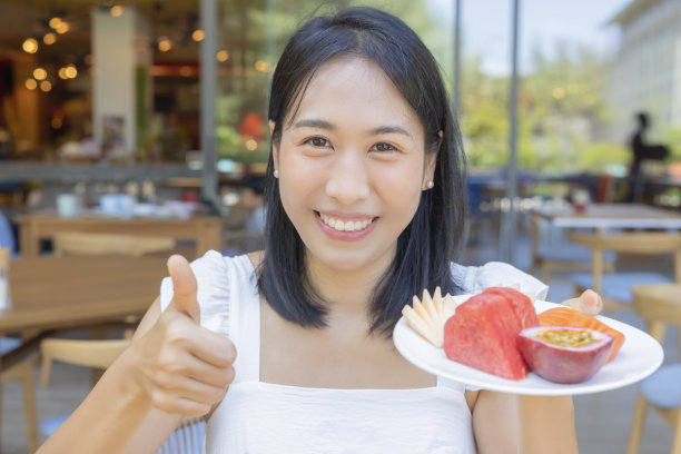 女人竖起大拇指，拿着西瓜、木瓜、甜瓜、百香果等水果图片下载