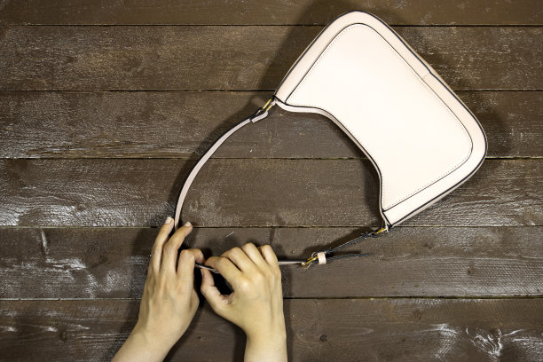 特写手持木桌子上的肩包图片下载