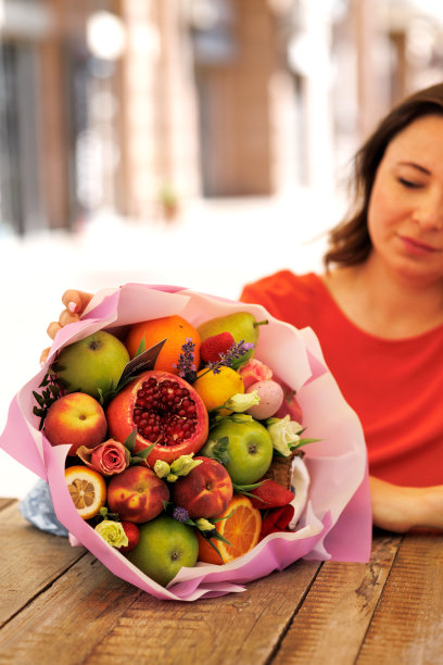 美丽的商业女性在红裙工作和赞赏礼物可食用的花束图片下载