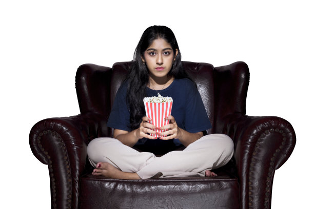 亚洲女人拿着爆米花坐在沙发上图片下载