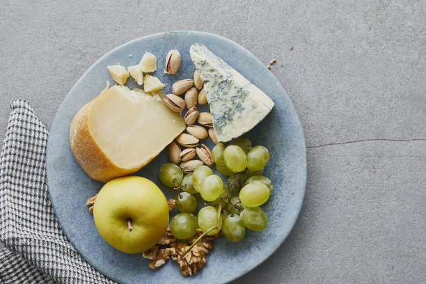 早午餐的盘子里有奶酪、苹果、坚果和葡萄图片下载