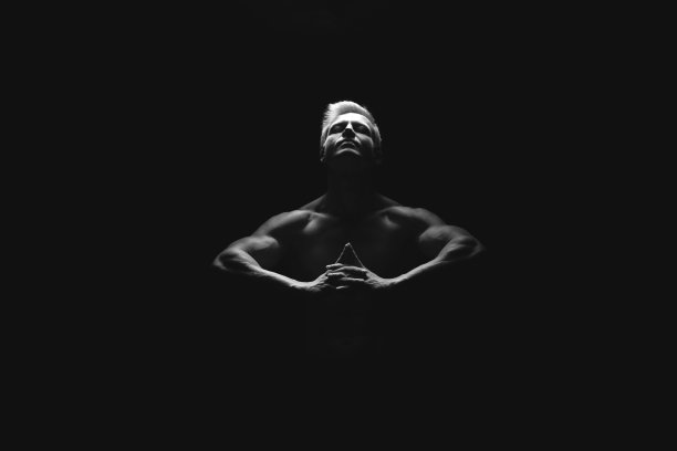 英俊的力量运动员在戏剧性的光。强壮的健美运动员拥有完美的肩膀，二头肌，三头肌，背部，三角肌和胸部。力量和动力图片下载