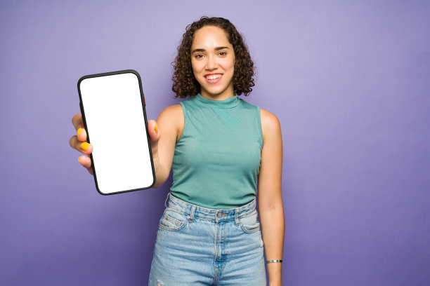 一个卷发的年轻女子的肖像，拿着她的新智能手机图片下载