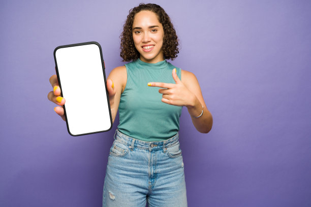 迷人的黑发女人用手指着她的手机图片下载