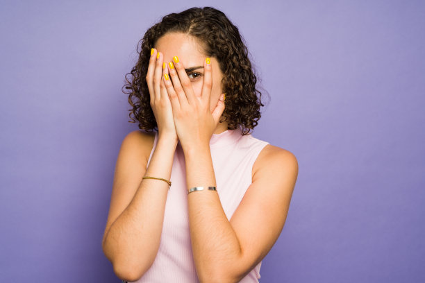 害怕的女人捂住她的脸和眼睛，看起来很不安图片下载