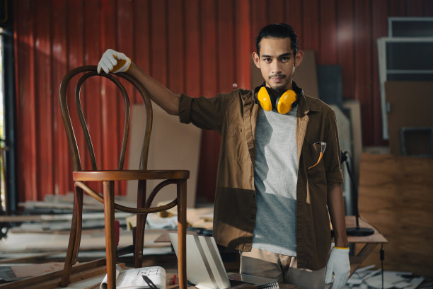 肖像年轻的亚洲男子木匠在木工车间图片下载