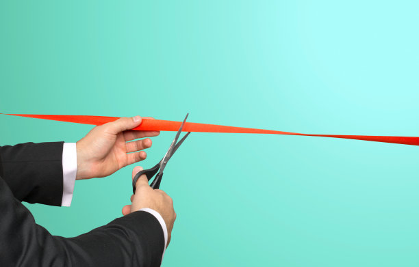 商人用剪刀剪红丝带图片下载