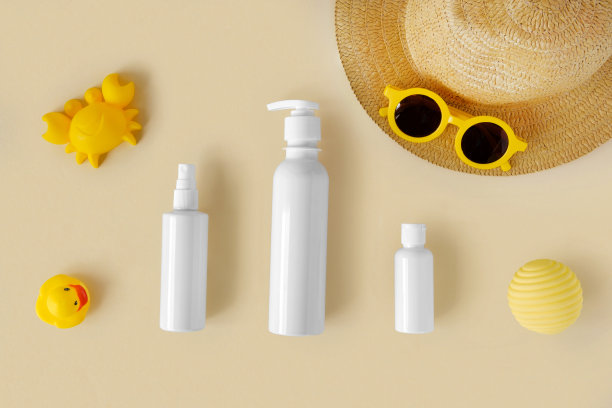 中性背景上的防晒乳管。米色桌子上放着塑料瓶防晒用品和儿童太阳镜和沙盒玩具。儿童护肤理念。对儿童防晒霜。婴儿化妆品。图片下载