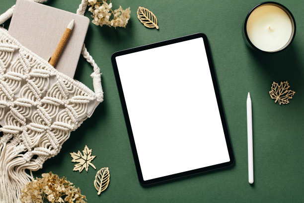 平铺桌子与平板样机，铅笔，编结袋，蜡烛，绿色背景上的秋天装饰。图片下载