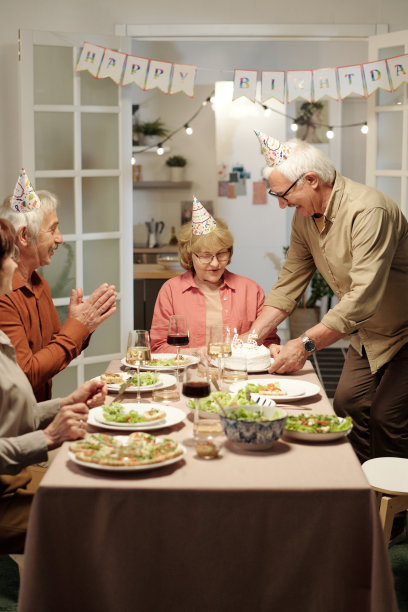 年长的男子鼓掌祝贺老年妇女的生日图片下载