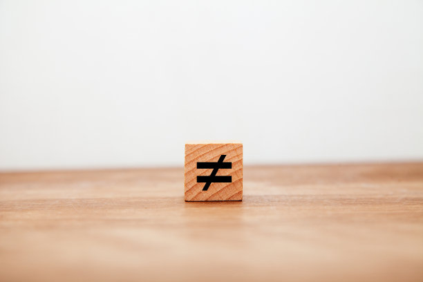 不平等的象征。≠。不平等的。写在木块上的。图片下载