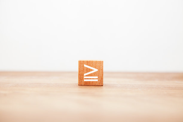 ≧象征。更大的平等。不等号。相同或更大。写在木块上的。图片下载