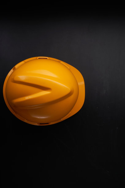 橙色安全帽贴着黑板图片下载